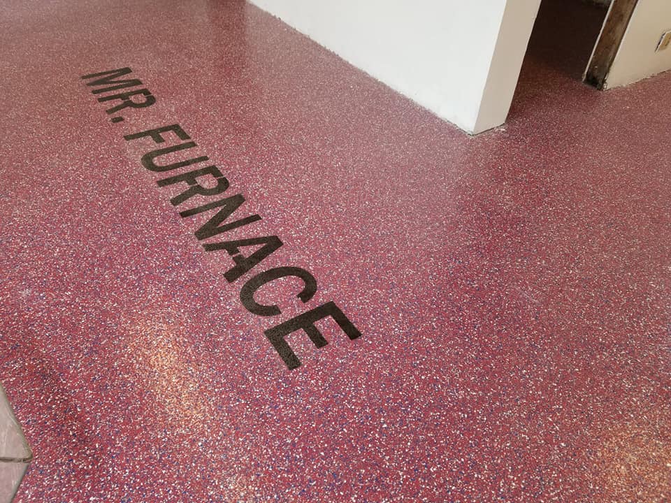 shop floor with decorative red, white and blue chips and business name in the flooring
