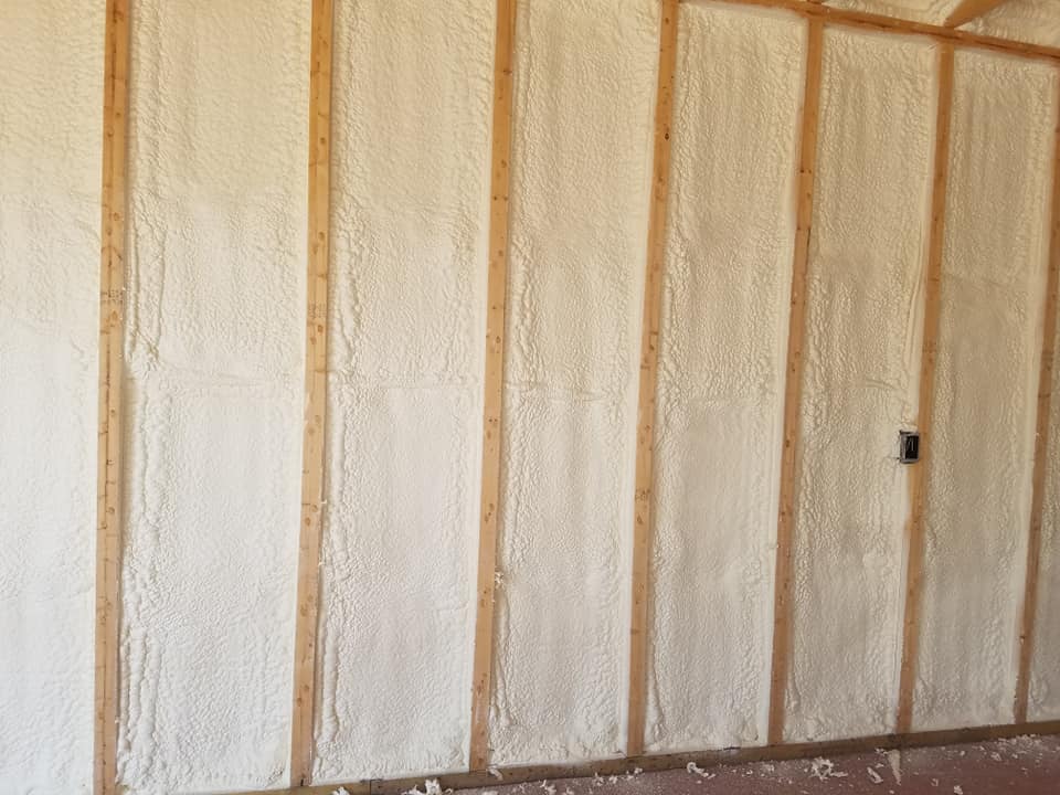 spray foam insulation applied between studs in wall of residential structure