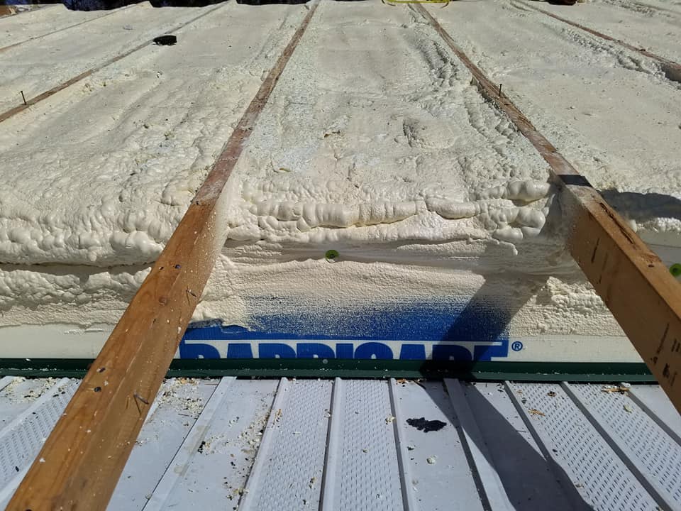 spray foam applied between rafters of a roof structure