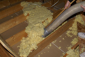 vacuuming out old, ineffective insulation material
